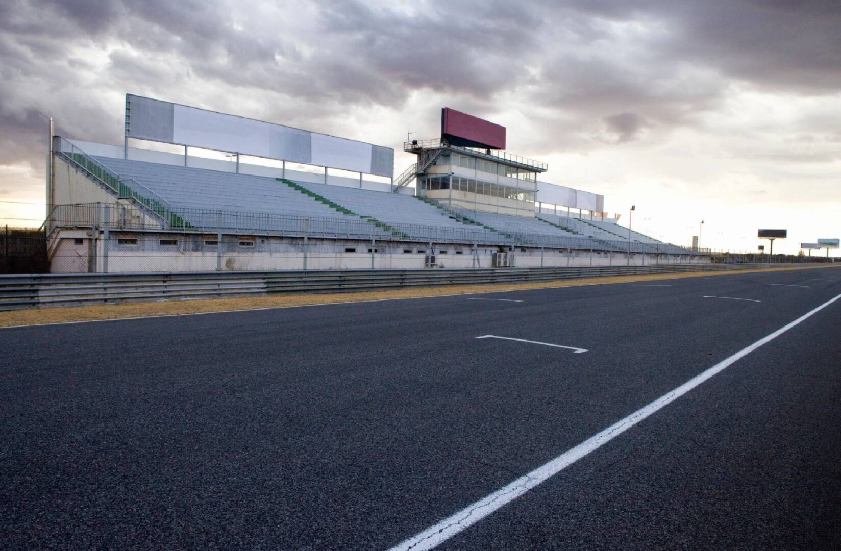 A road with an empty stadium in the background.